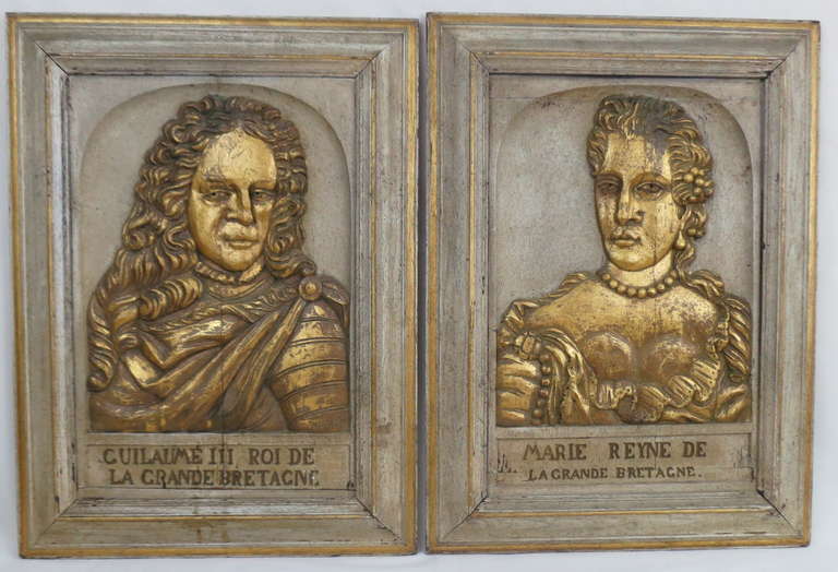 A pair of carved and gilded 19th century oak portraits of William and Mary.