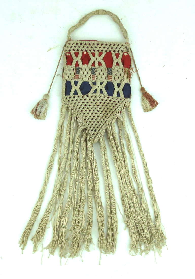 Sailor lace or macrame bag likely made as a gift for a sweetheart. Patriotic silk ribbons woven through the macrame, with a silk lining. New England origin.