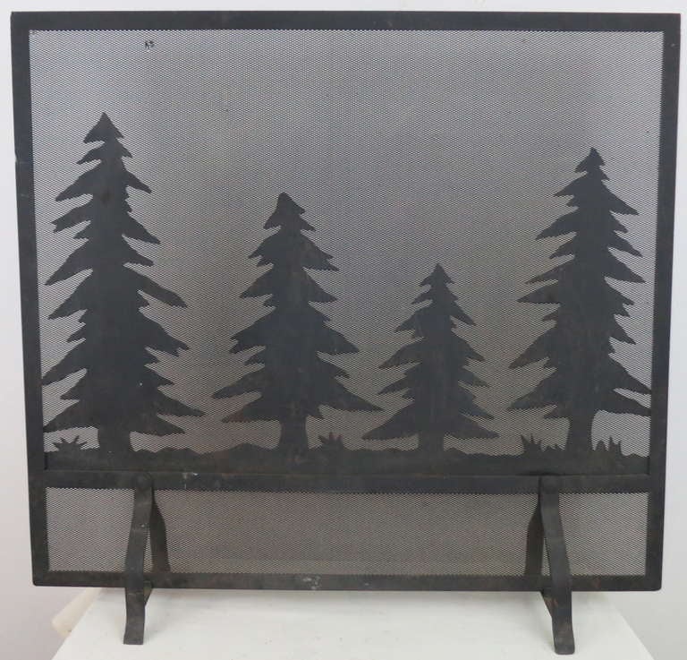 Wonderful pine tree motif cut out of sheet iron and attached to a wire screen, with an iron frame.