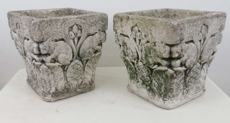 Cast stone planters with a great patina, fern and acorns surround the squirrels