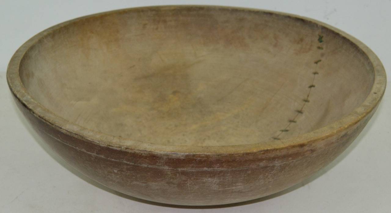 Turned 19th century wood bowl with early copper suture repair, dry heavily scrubbed surface. Out of round from shrinkage.