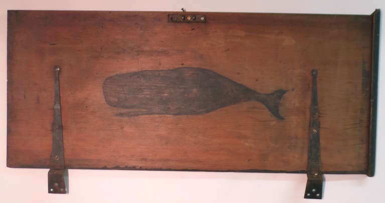 The fragmentary lid of a seaman's trunk with a wonderful and iconic image of a sperm whale. The lid was at some point in it's life rescued from a Sailor's trunk where it may have functioned as a talisman for a whale voyage. Now a wall hung graphic