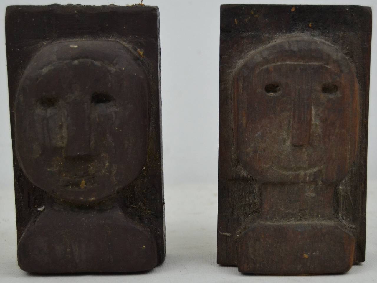 Two relief carved faces, simple and direct Folk Art statements.