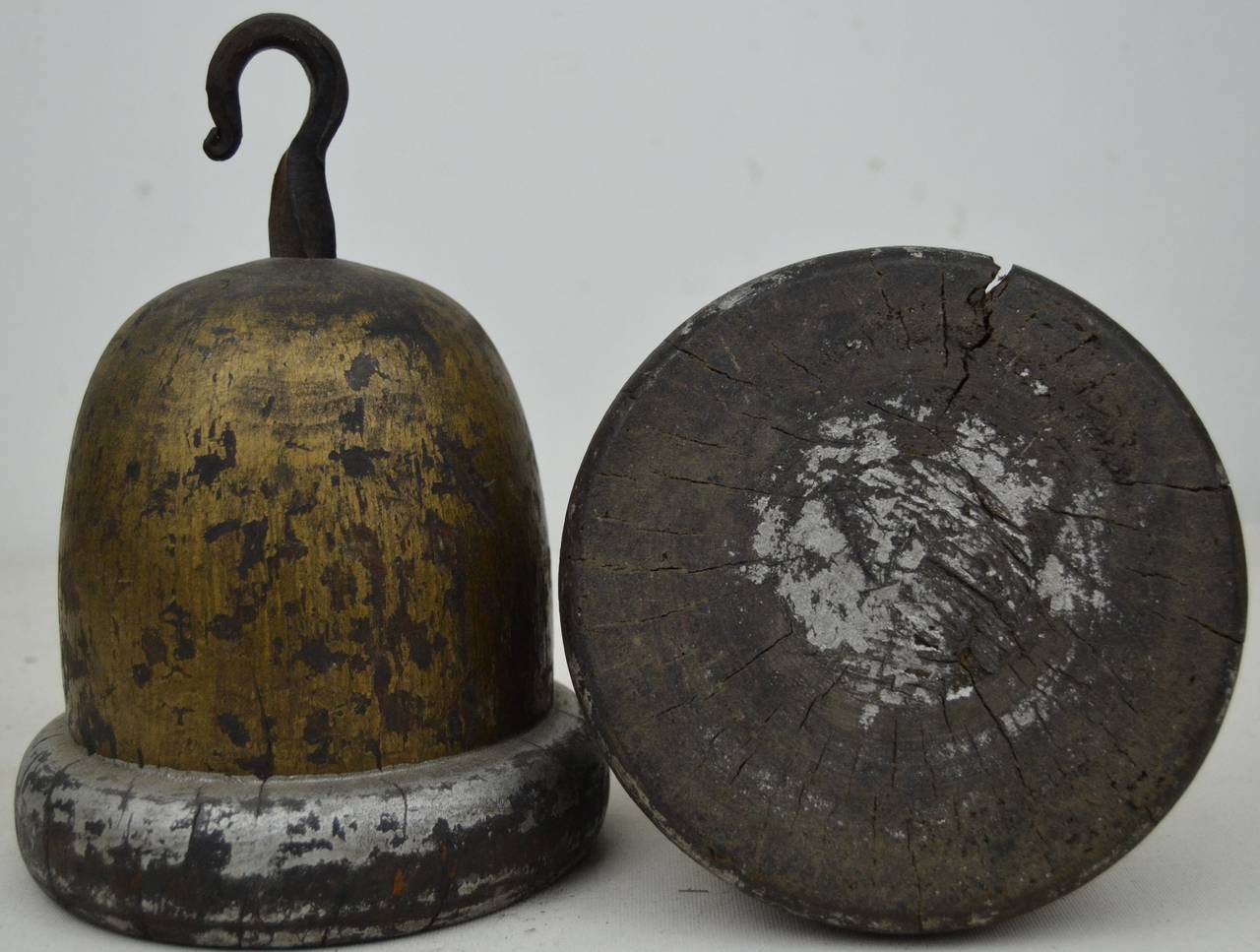 A pair of trade signs carved in the form of acorns. Each is from a single piece of wood and has traces of silvering and gilding. Hand-wrought iron hooks. English or American.