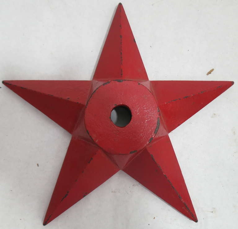 Cast iron star from a masonry building with particularly nice crisp casting and old fire engine red paint.