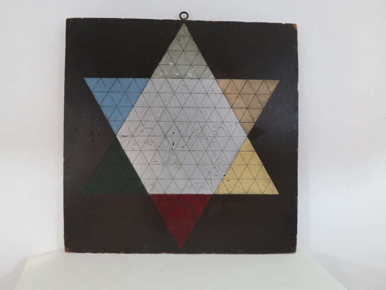 Six pointed star painted in enamel with inscribed ink lines, on chip board mounted to pine frame. Subtle and lovely coloration and an especially dynamic star.  The edges of the chip board and corners show wear, crackle in the painted surfaces of the