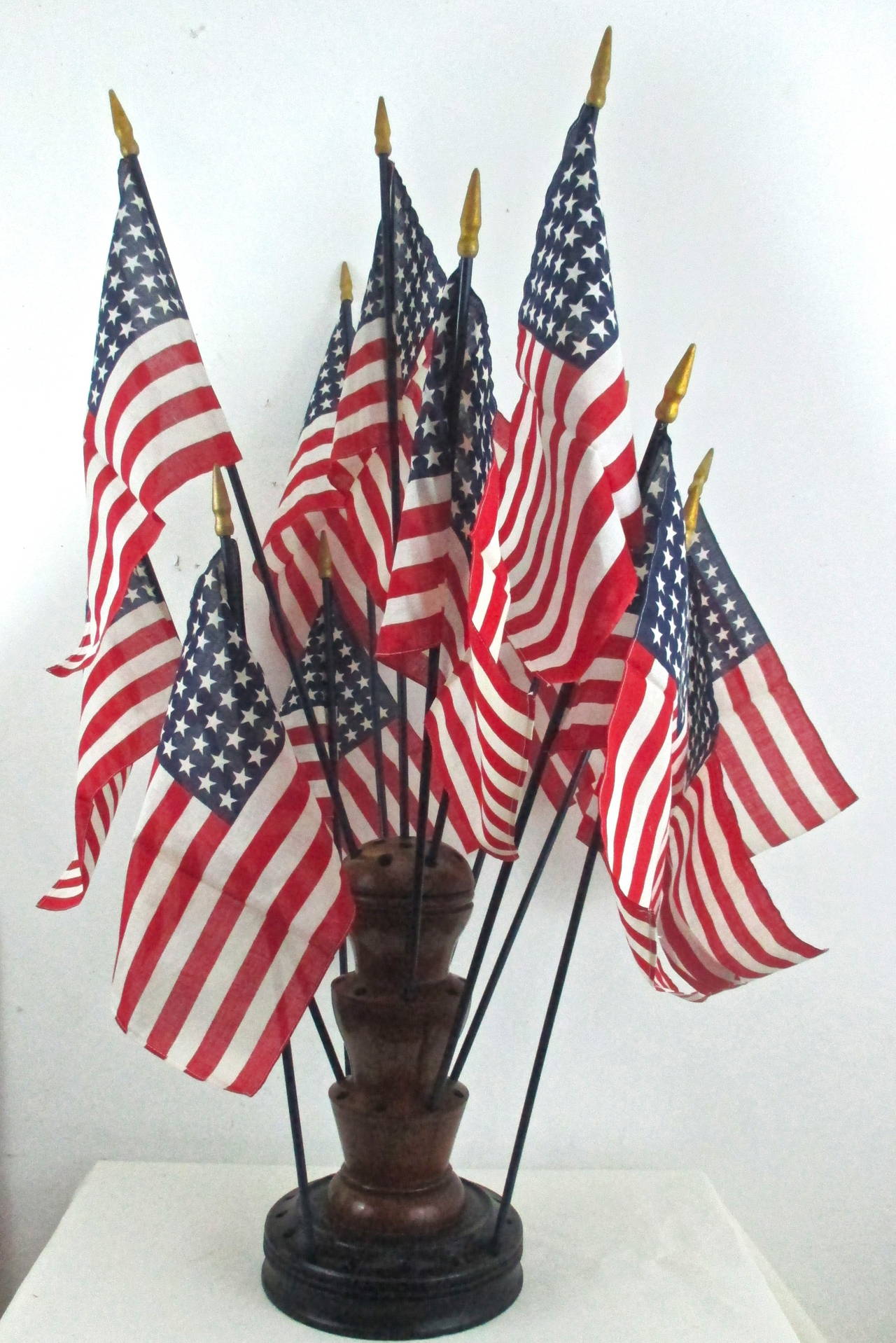 Large turned wood flag holder from a country store counter.  Holds 46 flags. Shown with a dozen old store stock 48 star flags which are included. One of the largest models of these flag holders we've seen. As shown with these flags height is 49