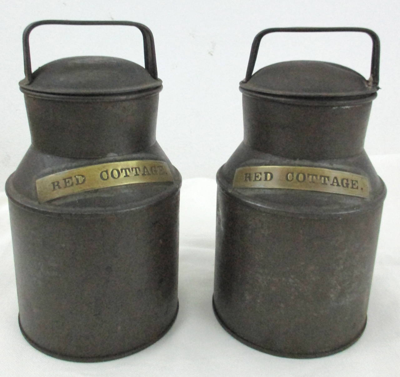 Charming pair of tin cream jugs of classic form with brass tag reading 