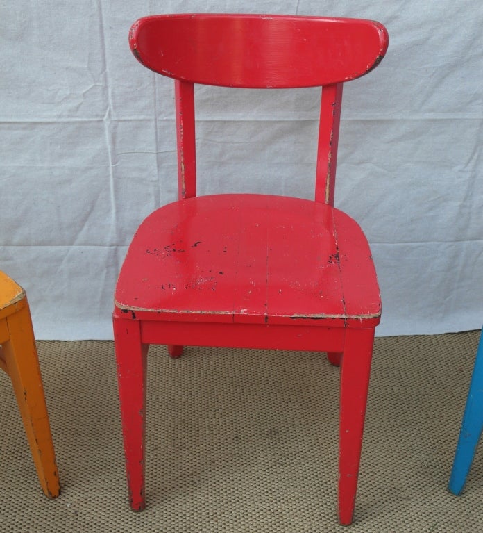 Set of painted wooden cafe chairs from the midwest. 2 each in blue, red, and orange. nicely scaled with ample wooden seats and curved backs. Sturdy and handsome