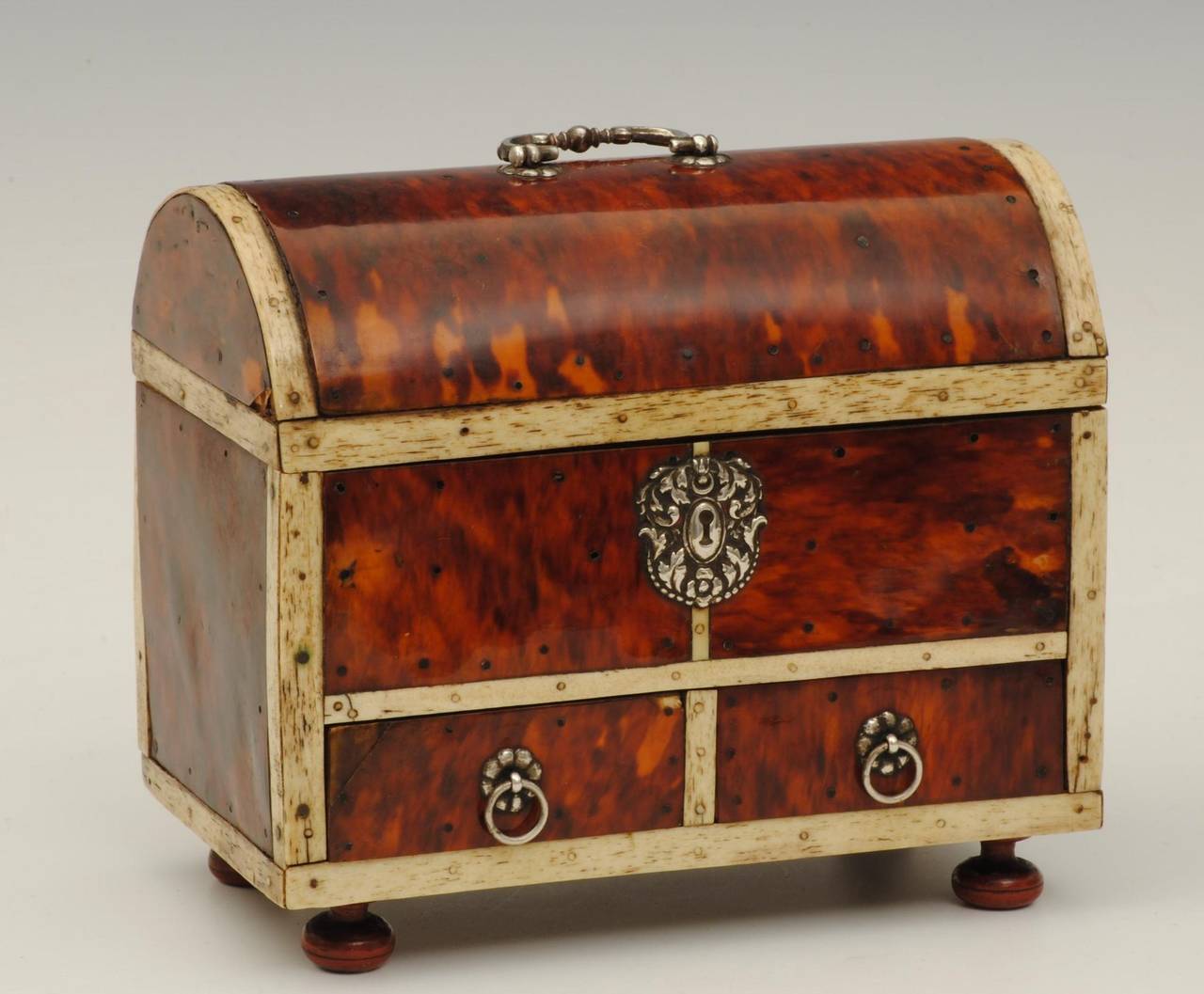 A tortoiseshell and bone mounted casket with silver handles and hinges