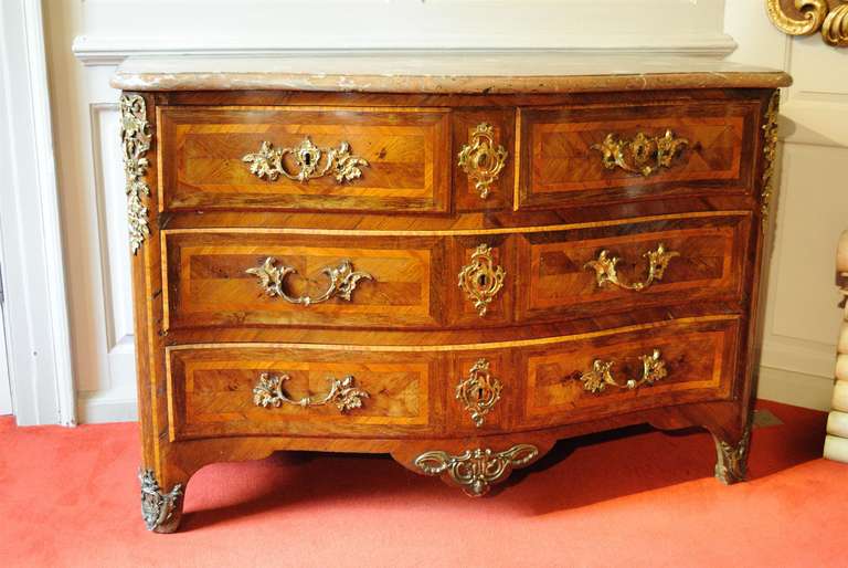 A fine serpentine Kingwood and rouge marble commode with ormolu mounts and handles, the drawers with tulipwood bandings.