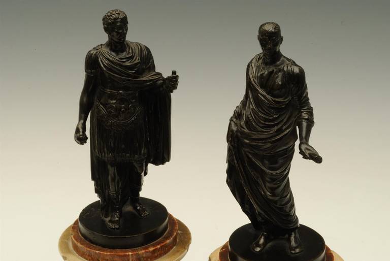 A good pair of early 18th century bronze figures of Roman emperors in classical robes and on the original marble plinths.