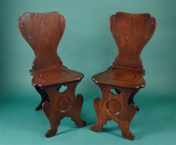 A great pair of 18th century mahogany hall chairs of cut out design.