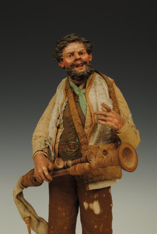 A good Neapolitan creche figure of a man playing the italian bagpipes with a fantastic polychromed head and glas eyes.