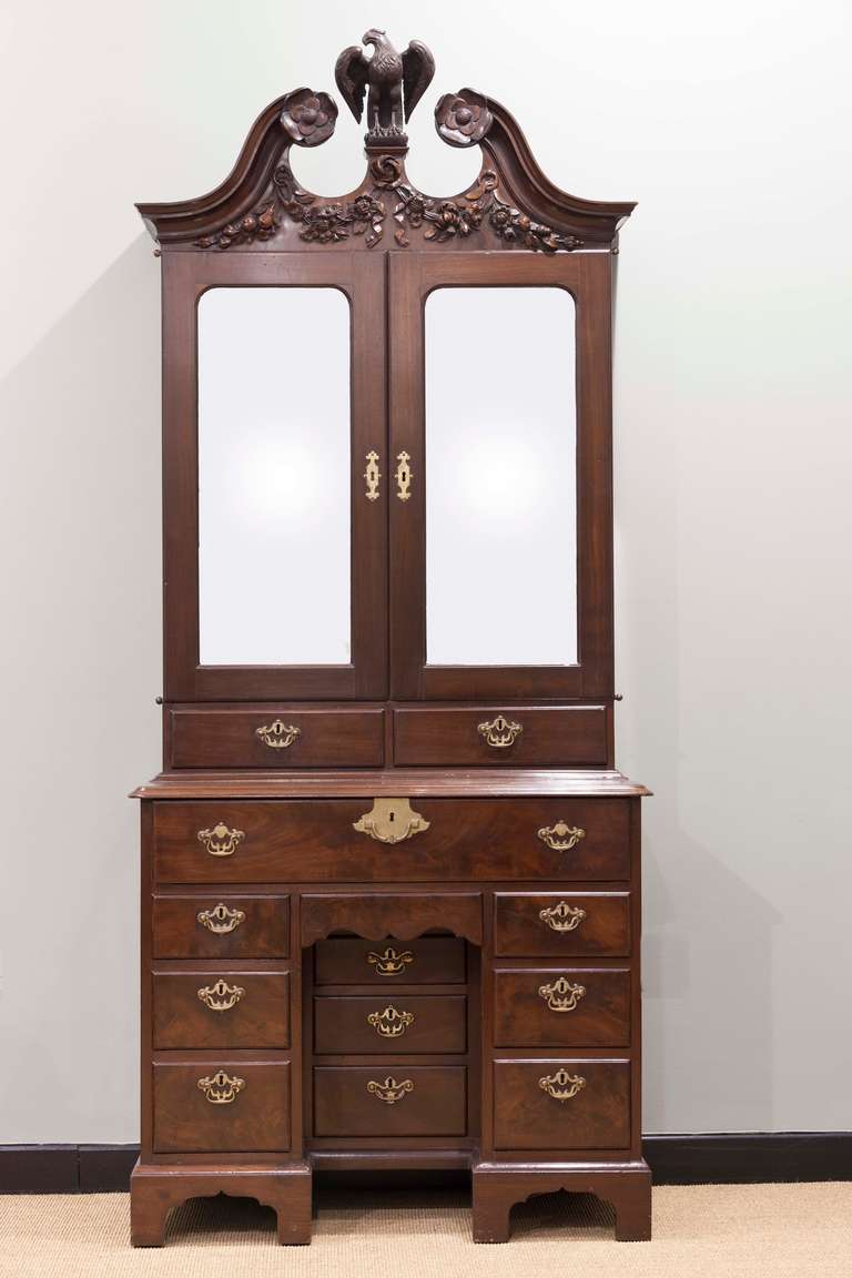 An important Irish 18th Century Mahogany kneehole cabinet. With carved swan neck pediment, surmounted by an eagle. Illustrated in 