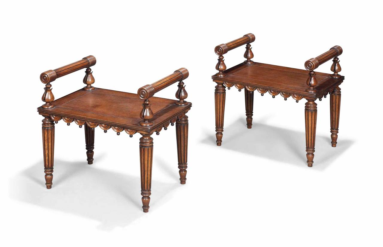 Pair of oak stools, each with raised arms, drapery edges and fluted legs.