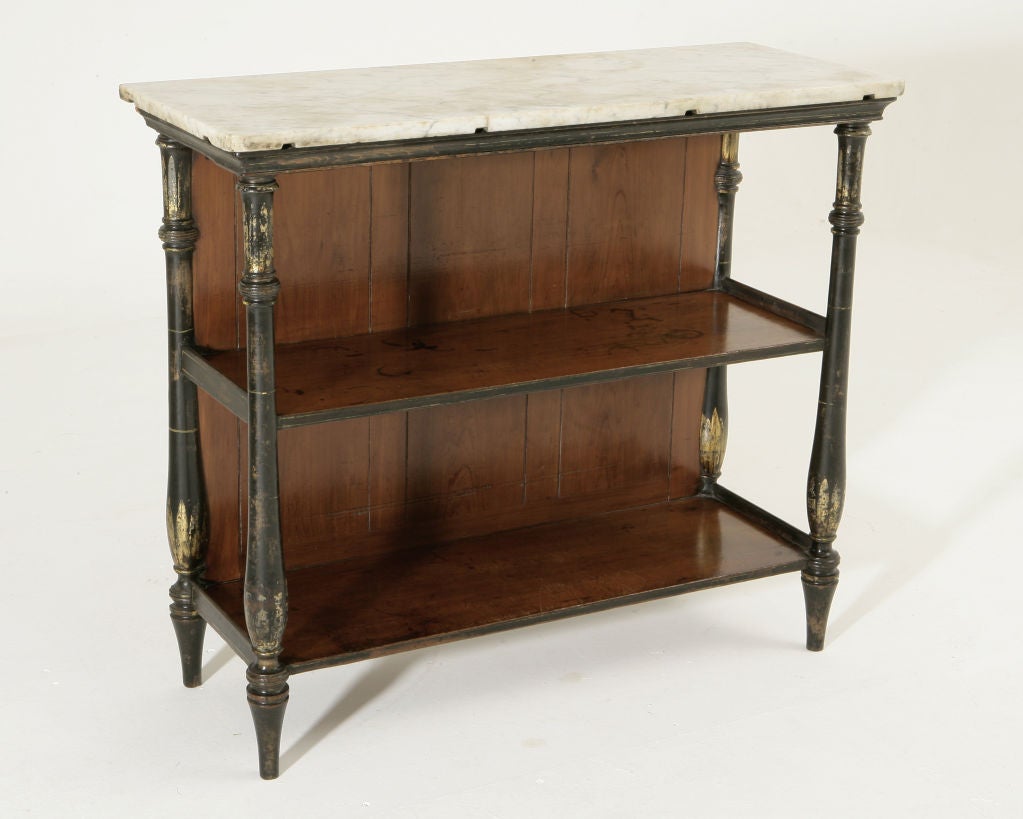 The rectangular marble top above two open tiers supported by turned and tapered uprights decorated with gilt leaf motifs, raised on turned and tapered feet.