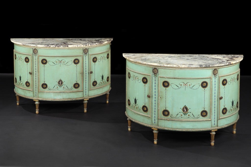 A very elegant pair of 19th century green and  painted commodes in the manner of George Brookshaw, of elliptical form with well carved and gilded mouldings and marble tops.  The carved troupe feet are extremely elegant. The painted decoration