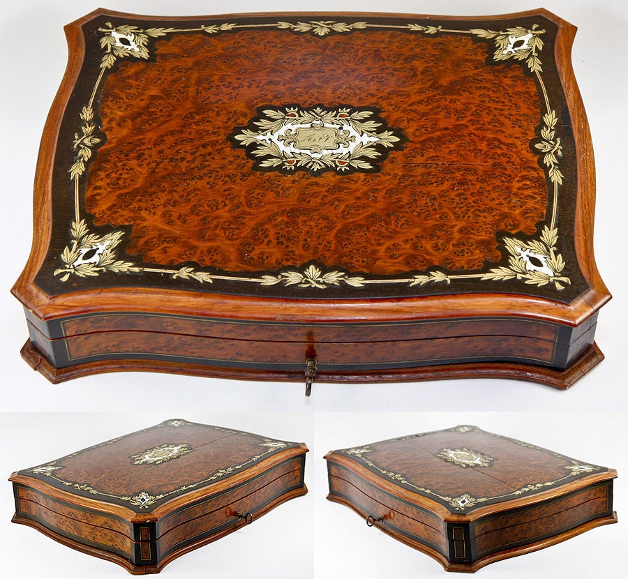 One of the most elaborately made and most beautiful of these Napoleon III era game boxes we've had in a long time, it's not only a superb serpentine form, but also is inlaid with precious natural materials and brass in a boulle manner of marquetry.