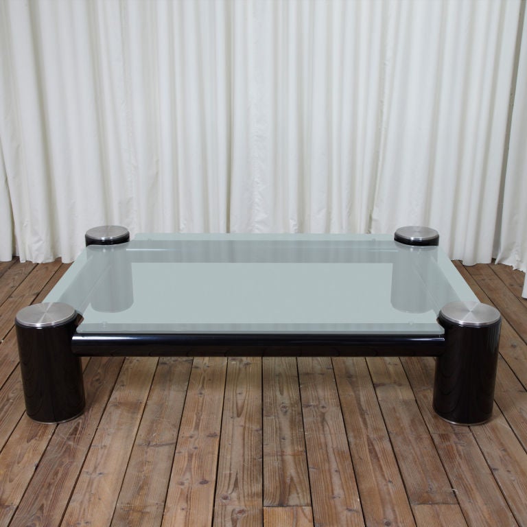 A beautiful coffee table with black and chrome cylinder legs and new heavy glass top. Screw on corner caps hold the glass top in place. 
Restored in a high gloss finish.