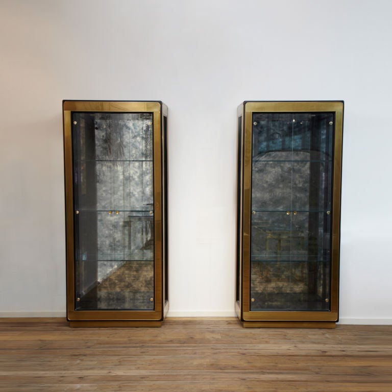 A pair of elegant brass vitrines from legendary Mastercraft furniture co in Nebraska 1970's.
Glass in sides and doors with 3 glass shelves and antique mirror back panels.
Both cabinets are lit.