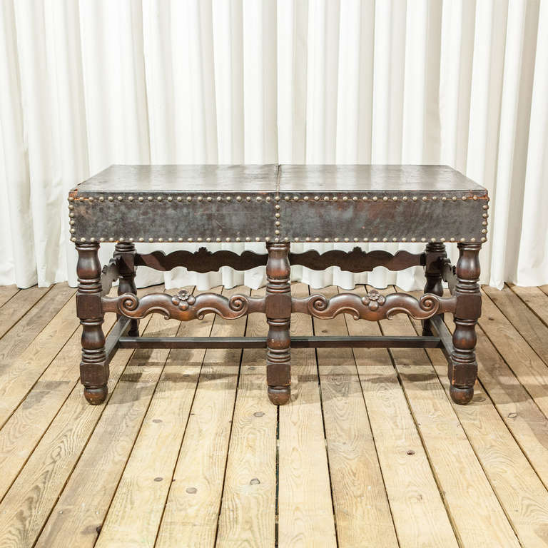 A stunning Baroque style leather writing table with wooden base and studded detailing.