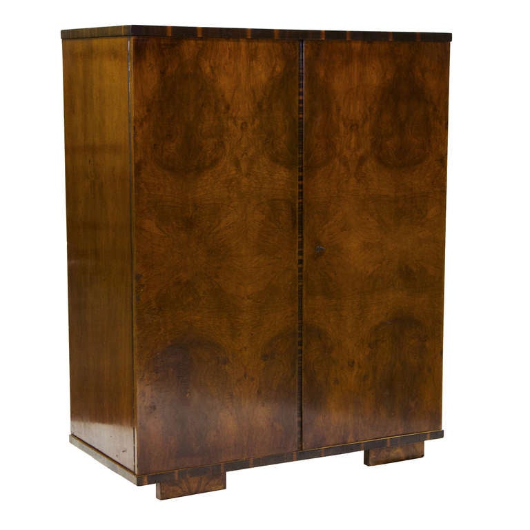 A splendid 1950's European Art Deco two door armoire with fitted interior. Nice Burl walnut front doors and Rosewood banding accents. This is a high quality Deco piece.