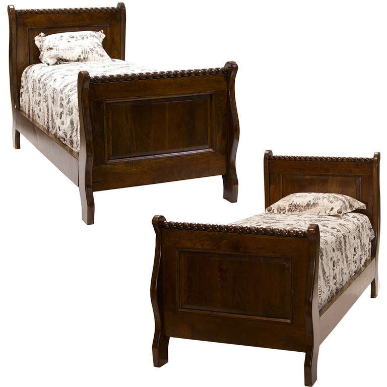 A handsome pair of twin beds made in Tennessee out of Cherrywood. Wonderful rope carvings and raised paneling. Very nice quality.