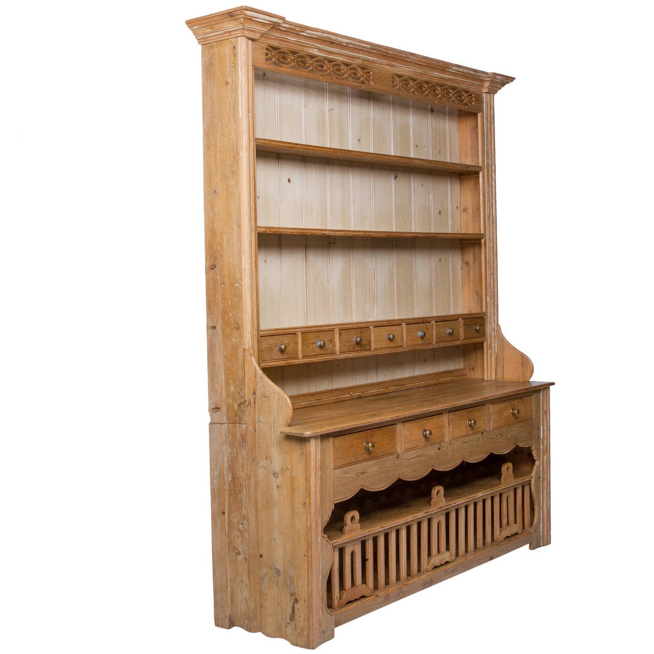 A vintage English pine dresser with plate rack back and spice drawers. The neat feature is the chicken coop base and above is a wine rack too. Several drawers are functional above the wine rack also. This piece was made from reclaimed wood and has