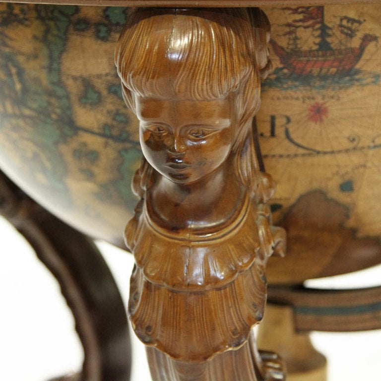 A fantastic mid-20th century Italian globe with fitted interior for glasses and bottles. A very nice quality globe made from metal. Fine carved base with three matching lady face motif. Oof the nicest quality globe bars I have purchased.