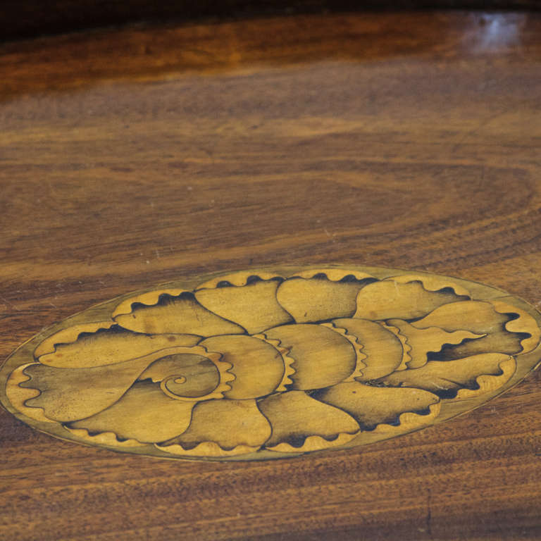 A classic English mahogany inlaid tray on stand. Wonderful scalloped edge and full shell inlay of multiple woods. The tray is recessed into a stand with an x-stretcher. Nice oval shape and size.