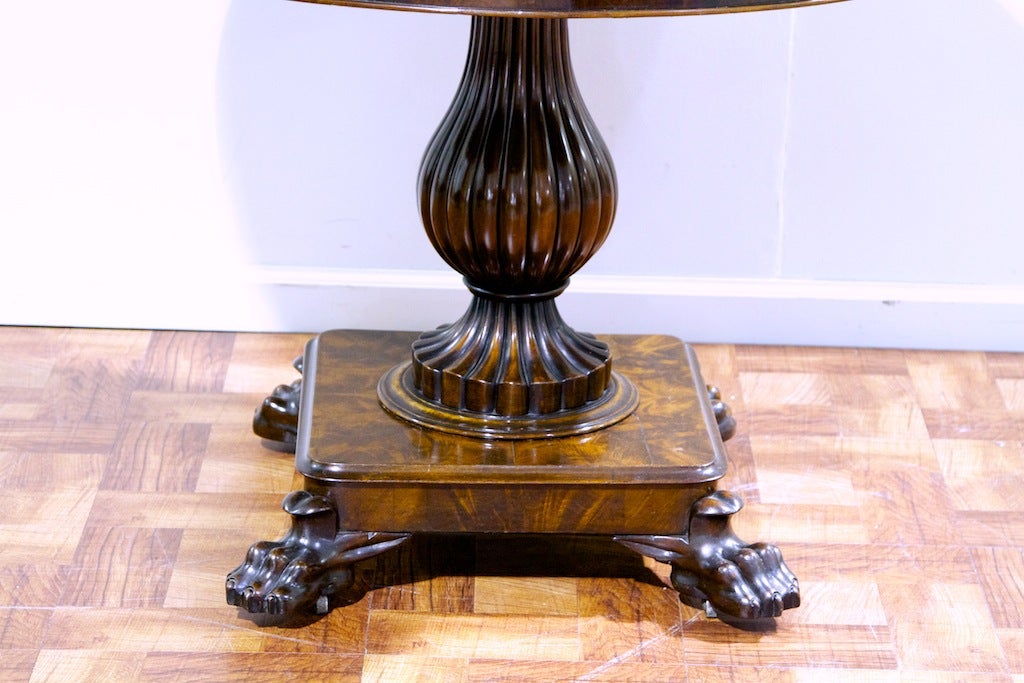 A fantastic marble top mahogany center table. Superb quality shown in the bulbous and reeded column the to a flamed mahogany platform and resting on meticulous claw feet with hidden castors. Marble is in its original condition. Fine Example of Louis