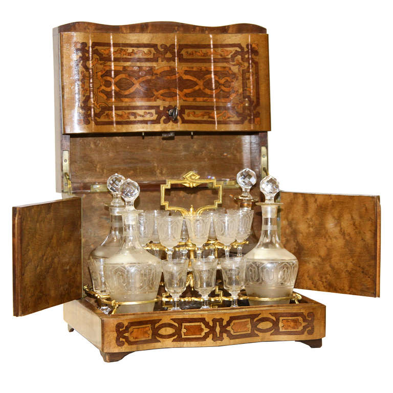 A fine French Tantalus set. Superb inlay applied to this case. The woods are maple, walnut, and mahogany. On the top is a centered piece of mother of pearl. The interior is set with a lift out tray and ormolu dividers. There are 16 cordials and 4