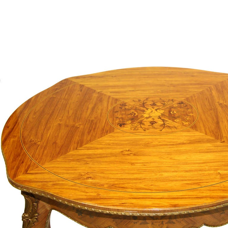 A quality Louis XV Kingswood and marquetry inlaid salon table. With iron pull out supports and leaves. The table is decorated with wonderful ormolu mounts and fine ormolu trim. Each leaf is 15