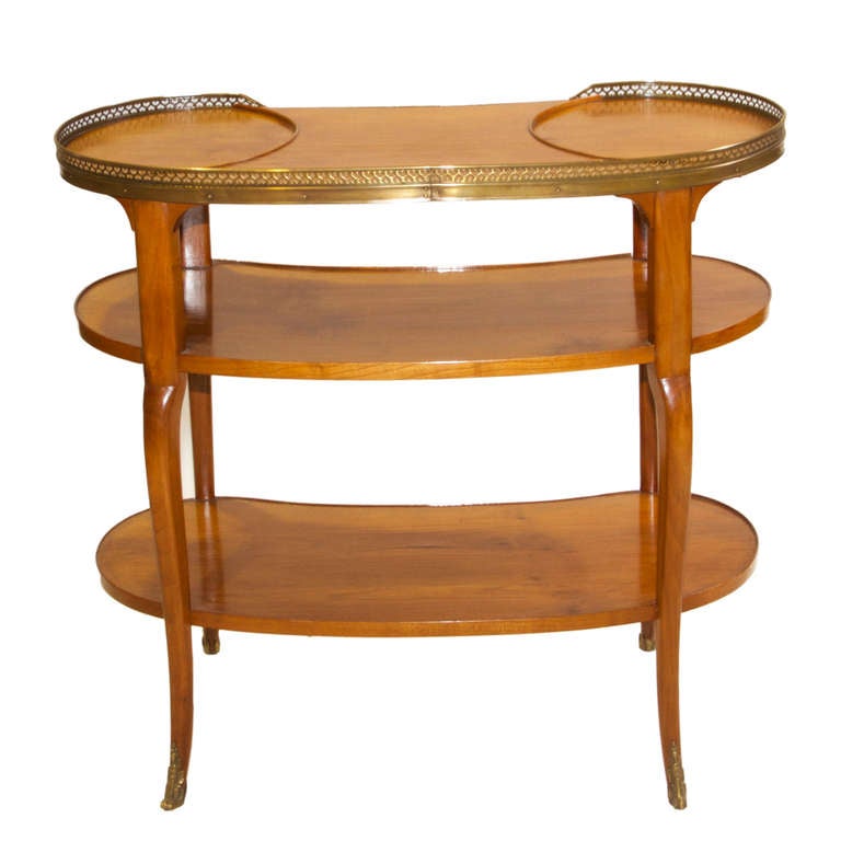 A quality cherrywood three tier kidney shaped dessert table with brass gallery and bronze mounted feet. The brass gallery has piercing of hearts. The top has two recessed holders. Very simple yet graceful piece.