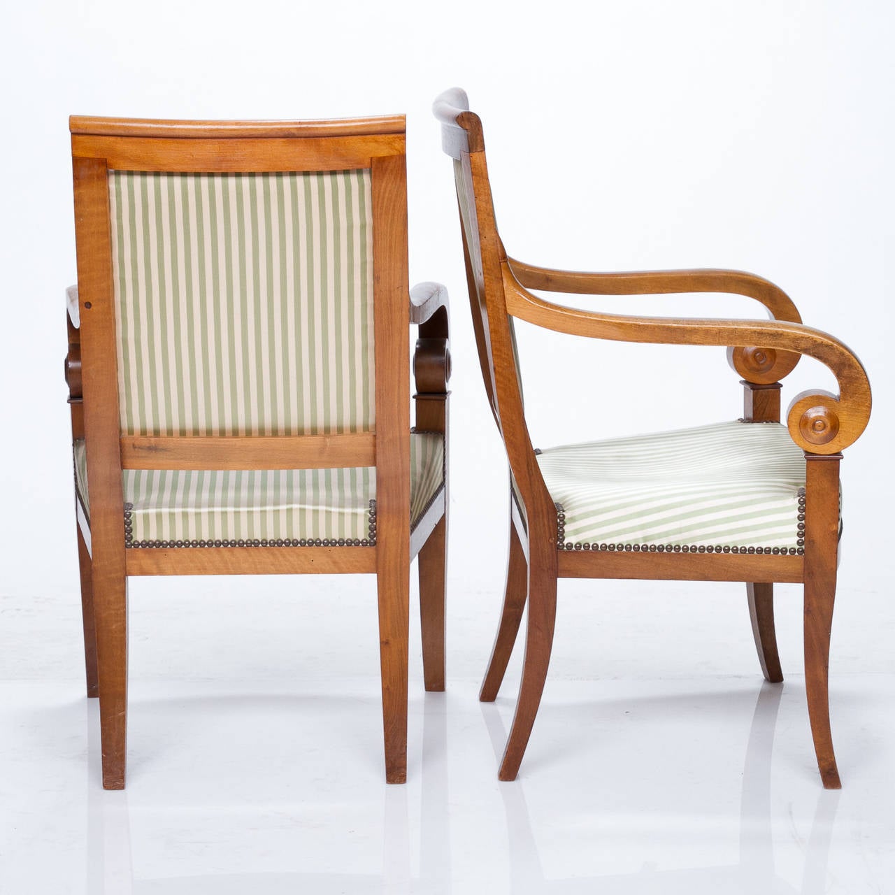 Heralding the Empire style, the furnishings of the Directoire period are elegant and gracious, reflecting the influence of Neo-Classicalism and the involvement with Italy. Hand-crafted from select French fruitwood, this exemplary pair of fauteuils