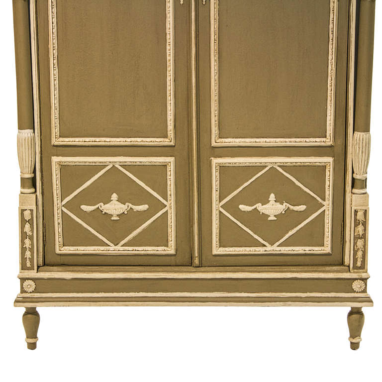 19th century neoclassical style corner cabinet. Very nice color and patina. Two turned columns flank two paneled and molded doors. The shaped top is centered with a raised urn.