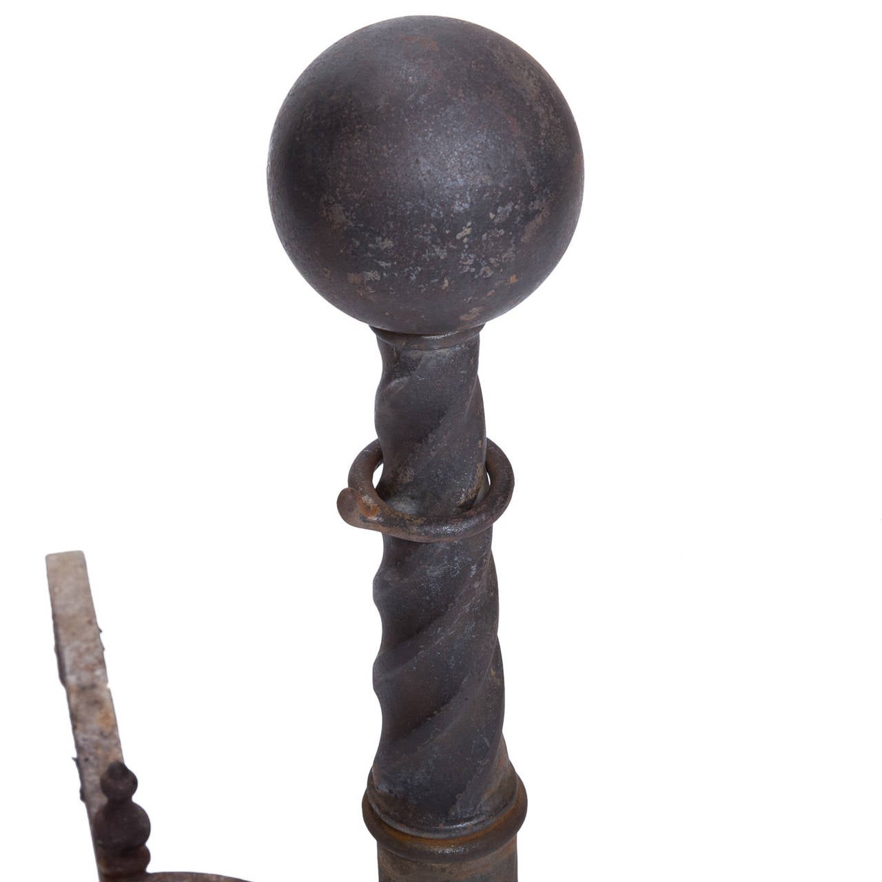 A strong pair of antique iron andirons with a decorative base leading to a twist column and cannonball top.