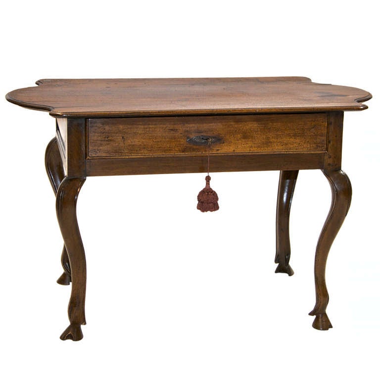 An absolute outstanding 18th century table on a hoof foot and cabriole legs. This walnut table shows a delightful patina and character. The top is shaped on both ends. There is one drawer and on the opposite side there are a row of raised heart