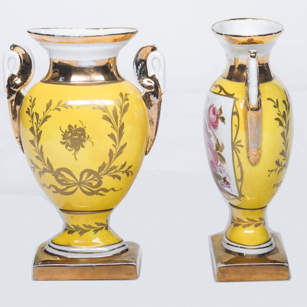 An exceptional pair of signed Old Paris urns with a base color of primrose yellow. Nice floral center and gold accents. Very nice swan neck handles. Made in France signed “Le Tallec Paris.” These are of high quality porcelain and hand painting,