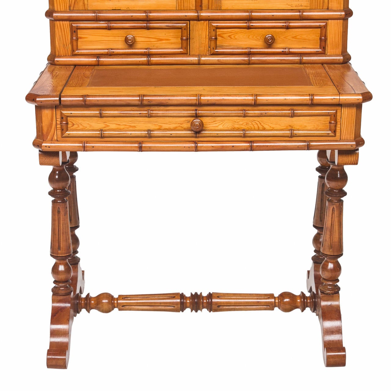 A fun!!! and unique French pine secretary with a faux bamboo look. The top cabinet opens to reveal adjustable shelves and has two doors. Above the doors there is a crown with turned urns used to create a pierce look for the gallery crown. Below the