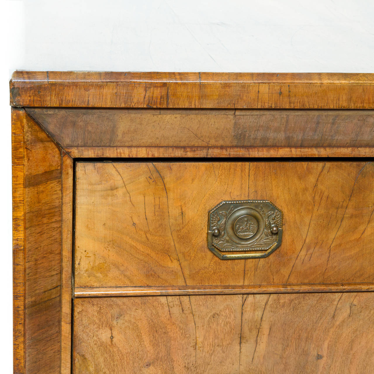 This is an exceptional walnut commode from the Biedermeier period. The construction of the piece is unusual for a Biedermeier piece. There are three graduated drawers (with a key) which are framed by a deep set beveled moulding. The piece rest upon