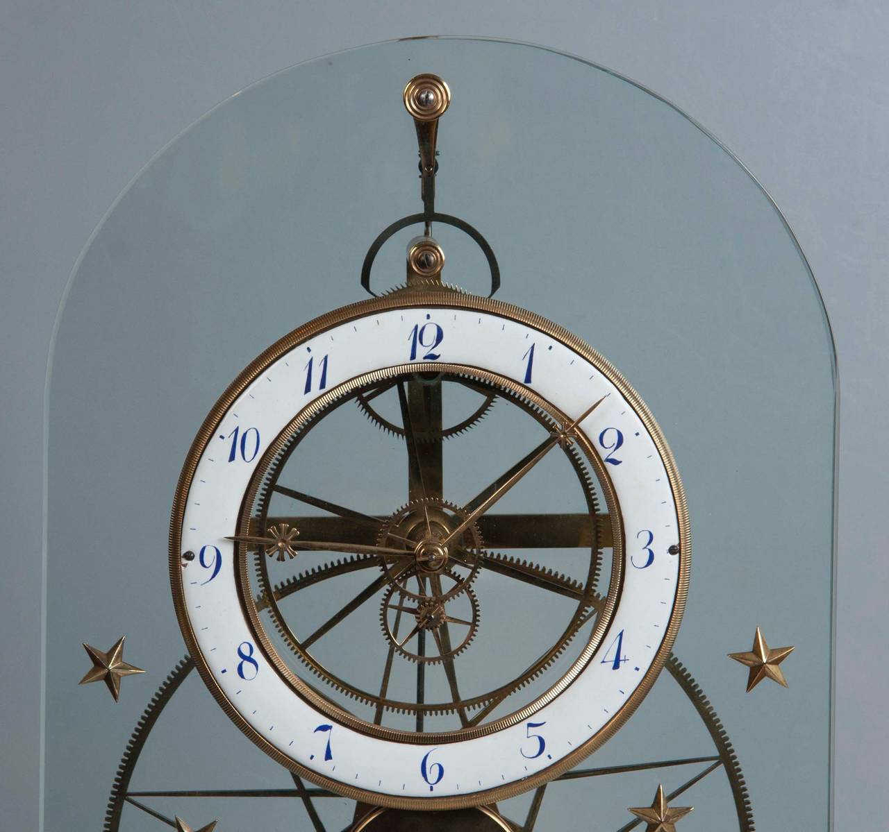 A late 19th century French glass skeleton clock having bronze star decoration.
