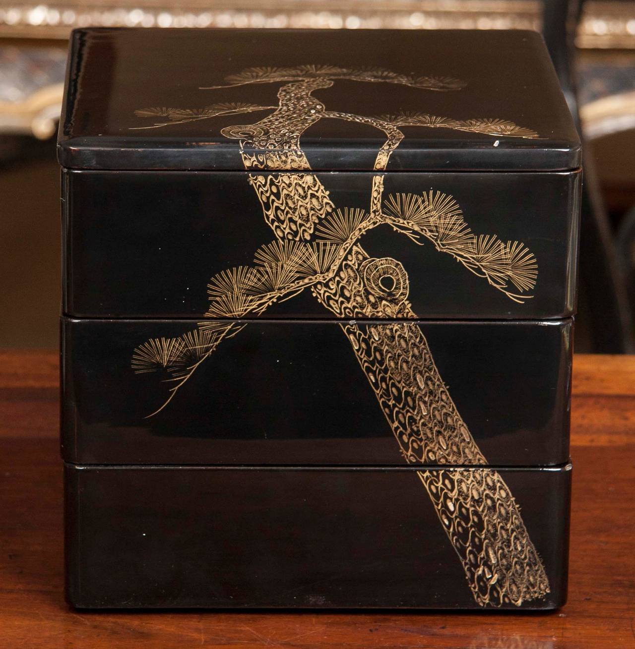 A late 19th-early 20th century Japanese black lacquer Bento box with gold pine motif.