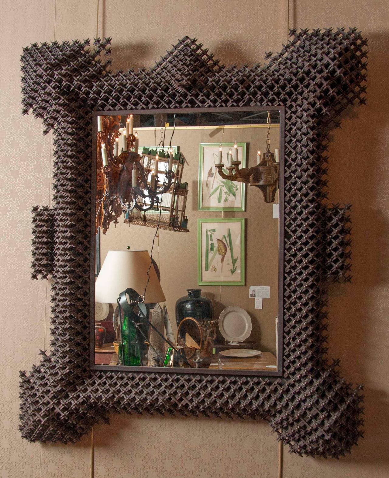 A large mirror with an unusually sized Tramp Art frame in a very intricate design.