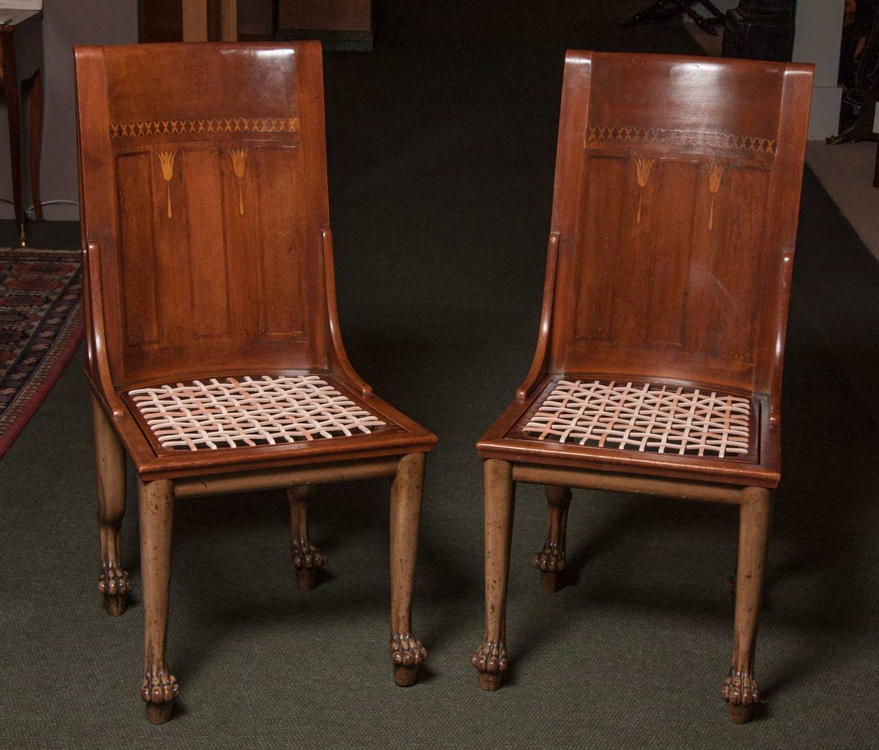 A pair of oak side chairs inlaid in Egyptian Revival style.