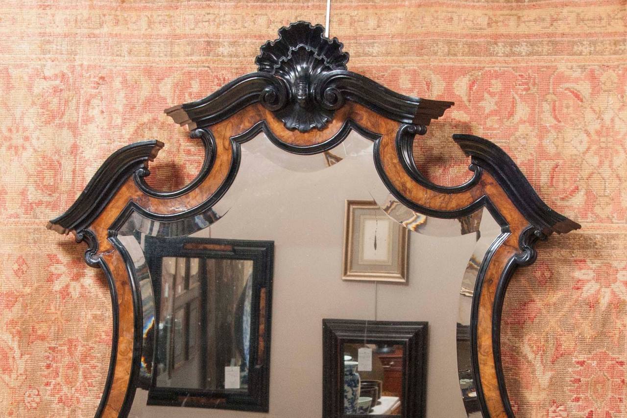 A wonderfully grand, late 19th century, Baroque style Dutch mirror with ebonized frame having burl inset panels and beveled glass.