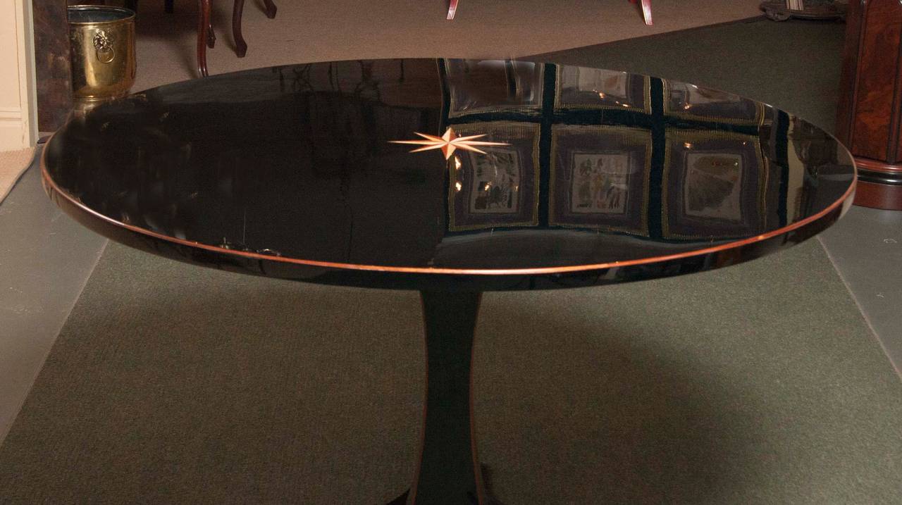 An astonishing ebonized Biedermeier center table having a single pedestal and mahogany trim.