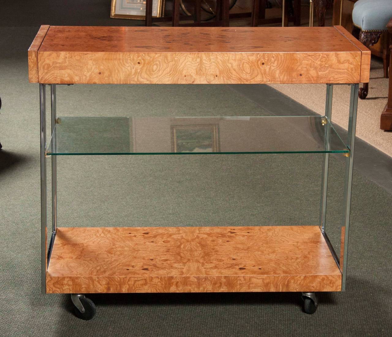 A Milo Baughman for Thayer Coggin three tier serving cart of burl olive wood with chrome plated metal on rubber casters.