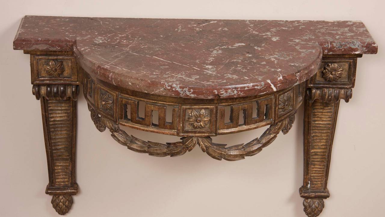 A Louis XVI period wall-mounted marble topped console having original burnished gilt finish. Minor repairs.